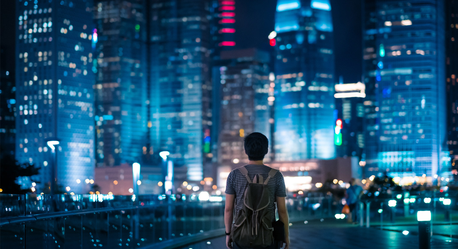 Cityscape at night  with person standing with their back to the camera 
