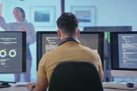 コンピューターの前で一緒に仕事をしている2人の人物のサムネイル
